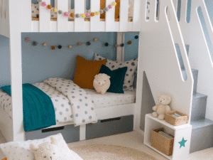 Neutural bedding featuring bunk bed with stairs on the front of the bed