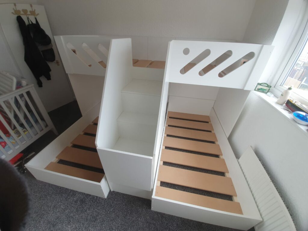 m shape triple bunk with gate on the stair case. in white. funky bunk beds design. single mattress size.