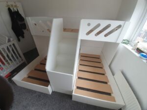 m shape triple bunk with gate on the stair case. in white. funky bunk beds design. single mattress size.