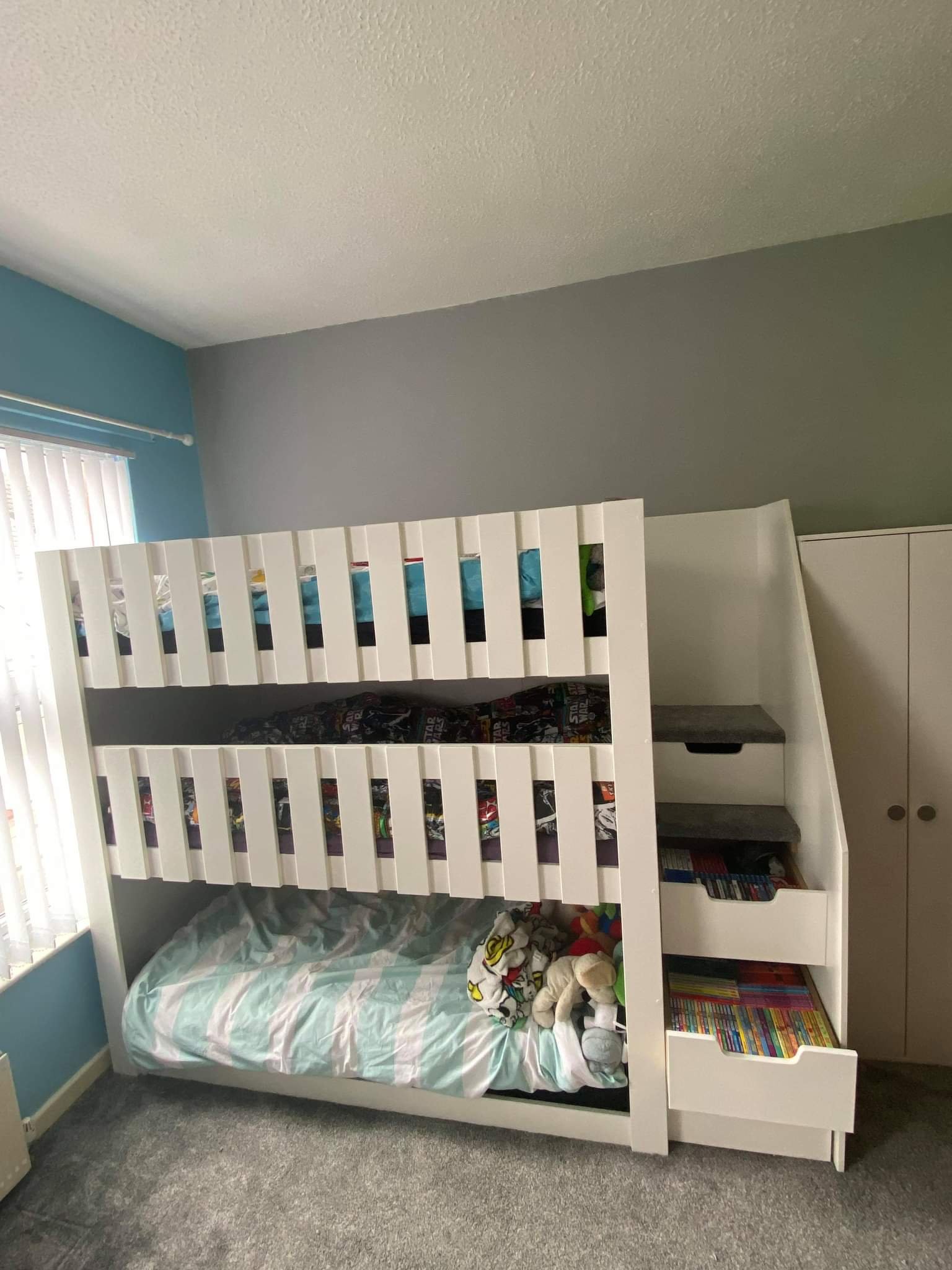 triple tier bunk bed with stair case. drawers in the stairs. sleeps 3. storage. childrens books.