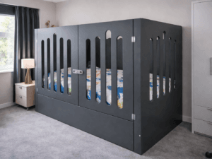 Dark grey enclosed safety bed with locking doors and vertical slat design in a modern child’s bedroom, styled with neutral décor and soft lighting