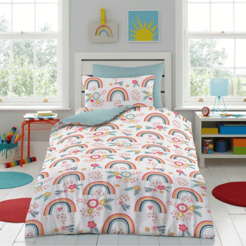 Rainbow Dreams Children’s Duvet Cover Set featuring colorful rainbows, sunshine, and flowers on a white background, styled on a single bed in a bright kids’ bedroom with playful décor