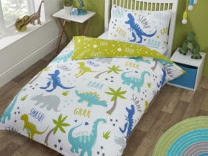 Roarsome Reversible Single Duvet Cover Set featuring colorful dinosaurs, palm trees, and fun text like ‘Roar’ and ‘Grrr’ on a white background, styled in a bright children’s bedroom with green walls and playful décor
