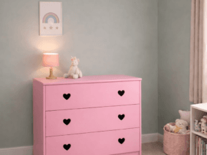 Pink Sweetheart 3 drawer chest with heart-shaped handles in a modern children's bedroom, styled with soft pastel decor, lamp, and toys for a clean and cosy look.